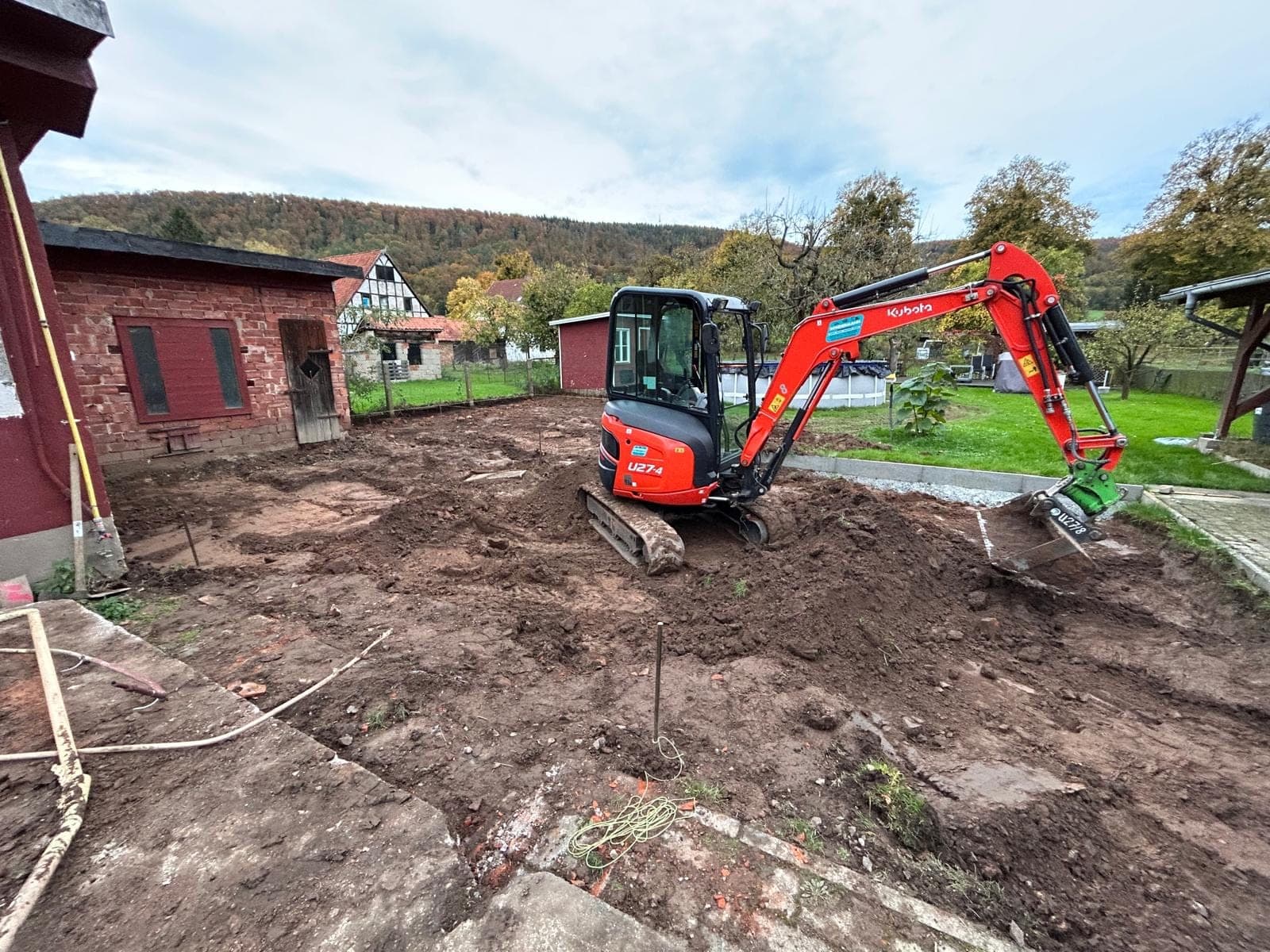 Minibagger auf vorbereitetem Grundstück bei Erdarbeiten